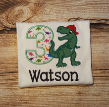 Load image into Gallery viewer, Childrens personalised birthday tshirt, Childs embroidered dinosaur shirt, kids dino top, t-rex in a baseball cap tee, childrens clothes
